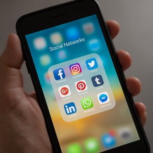 Mobilní telefon držený v ruce s otevřenou obrazovkou 