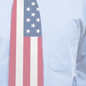 Detailní záběr na muže v světle modré košili s náprsní kapsou, který má na sobě kravatu s motivem americké vlajky.