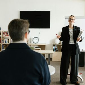 Lektor angličtiny TOPLINGVA při výuce cizího jazyka se studentem v učebně, zaměřeno na kvalitní a srozumitelnou výuku.