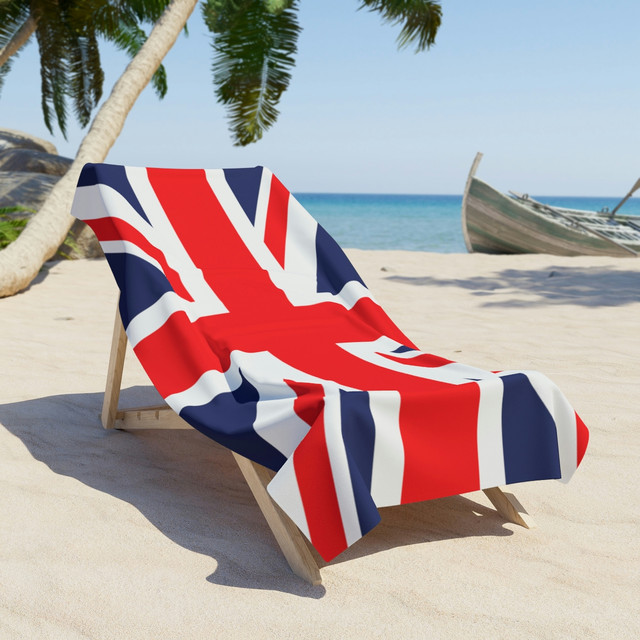 Lehátko s britskou vlajkou na pláži s palmami a mořem - symbol léta a angličtiny.