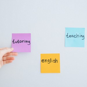 Tři barevné lepící lístky (Post-it) na bílé stěně s ručně psanými anglickými slovy: 