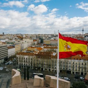 Letecký pohled na Madrid se španělskou vlajkou v popředí. Španělština propojuje Evropu s Latinskou Amerikou a otevírá možnosti cestování i práce.