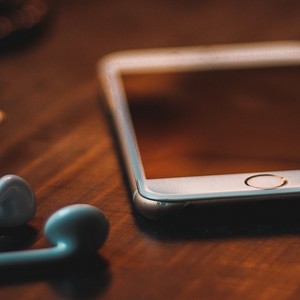 Mobilní telefon a sluchátka, symbolizující rychlé a dostupné tlumočnické služby na dálku.