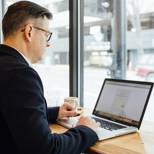 Muž pracující na počítači, symbol online vzdělávání a rozvoje digitálních dovedností v kurzech PC v jazykové škole TOPLINGVA.