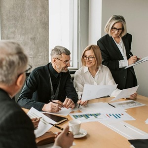 Skupina zaměstnanců firmy při práci symbol spolupráce a firemního vzdělávání v cizích jazycích, kurzy angličtiny a dalších jazyků zvyšují konkurenceschopnost společnosti.