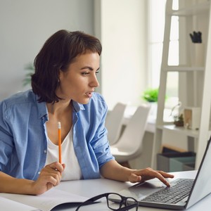 Žena se účastní online lekce angličtiny a procvičuje své jazykové dovednosti z pohodlí domova.