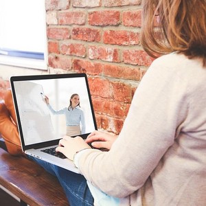 Žena se učí angličtinu online, zapojená do interaktivní výuky z pohodlí domova.